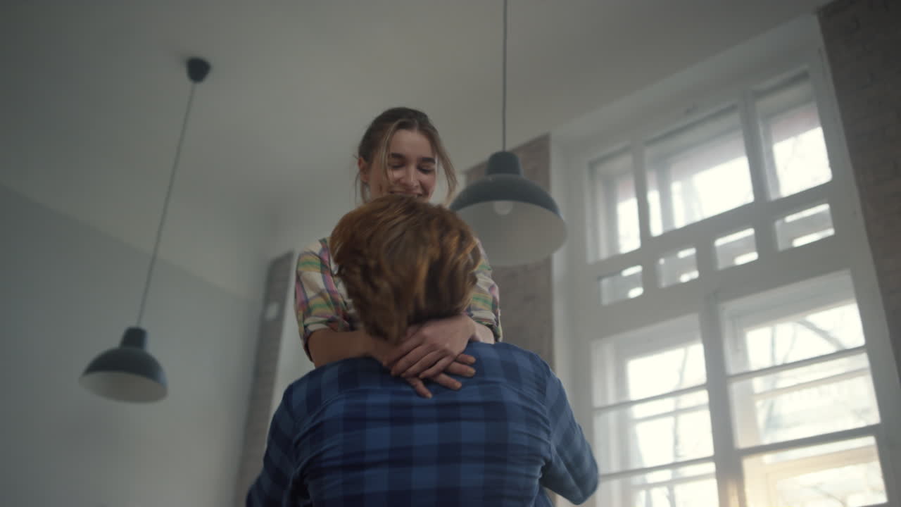 흥분된 가족이 집 안에서 새로운 집을 즐기고 있습니다. 남자의 손이 집에서 소녀를 잡고 있습니다.