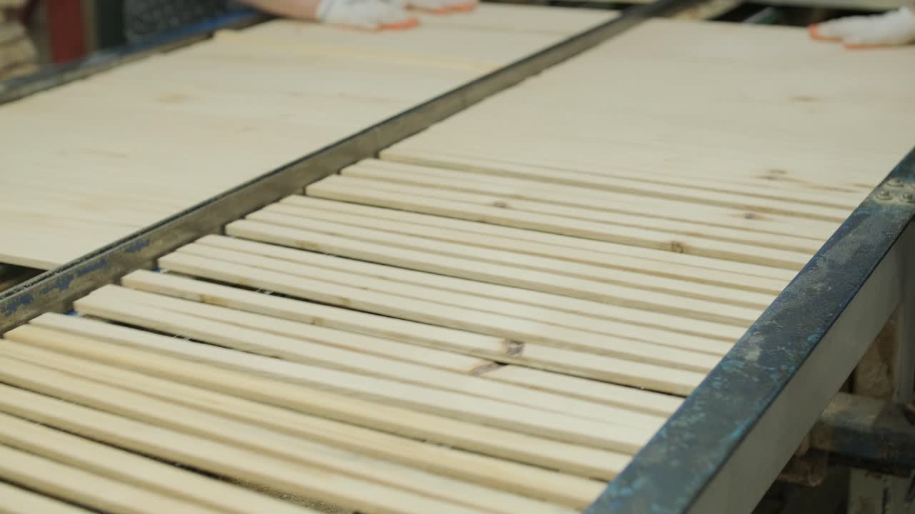 Operai che assemblano pannelli di legno con listelli su una linea di produzione