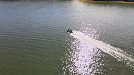 pontoon boat driving across open water on lake