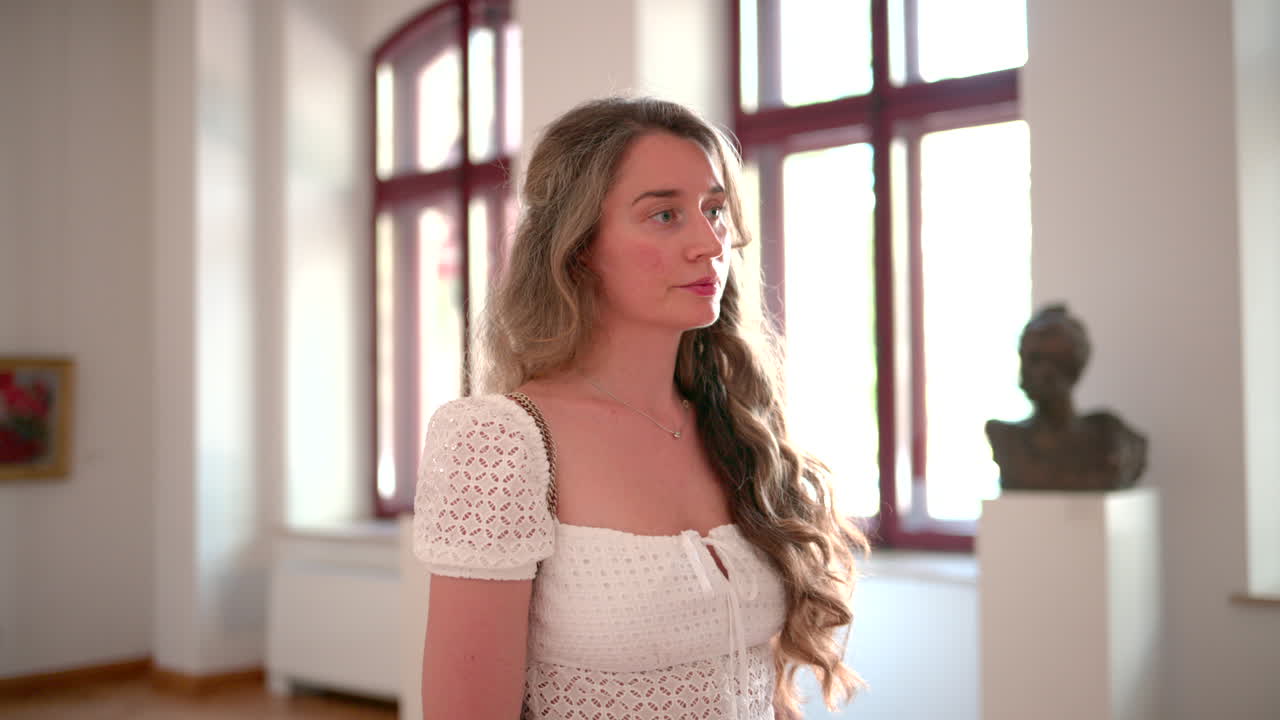 Woman visiting an art museum, admiring paintings