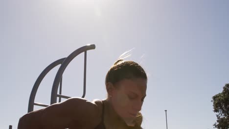 mujer caucásica deportiva haciendo ejercicio en un gimnasio al aire libre durante el día