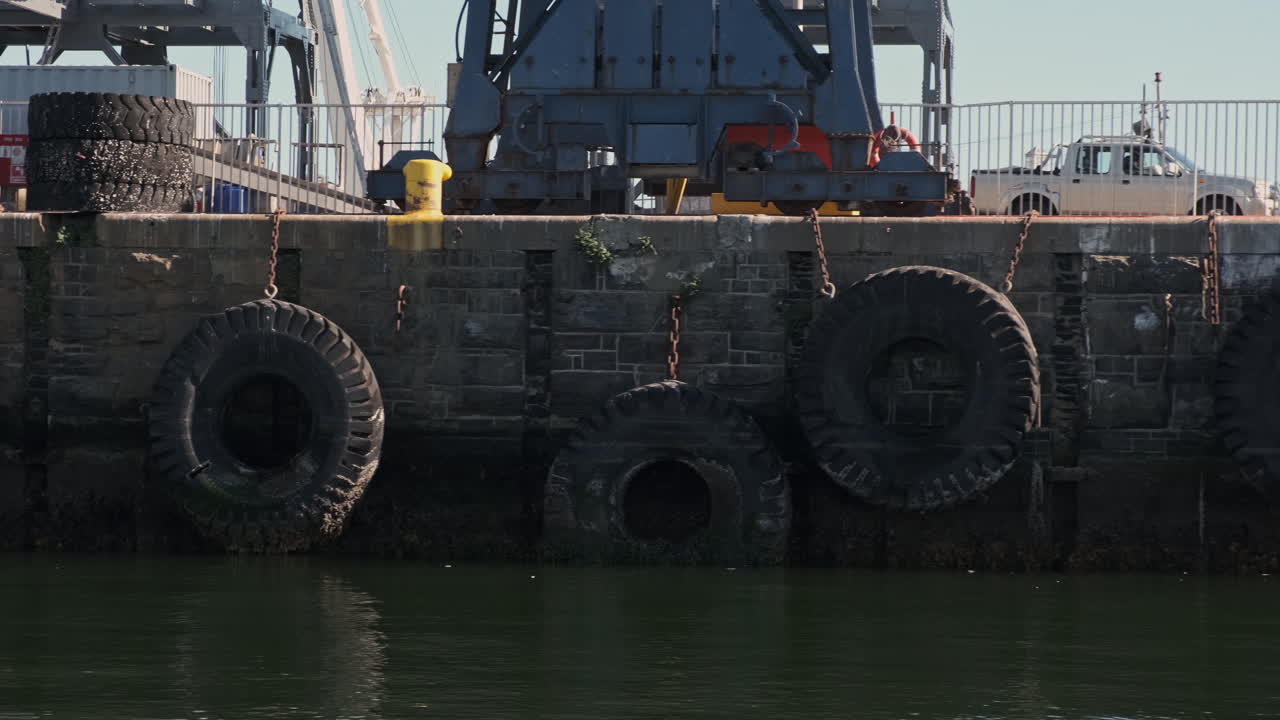 Row of tyres safety bumper on Cape town harbour concrete stone wall waterfront dolly right