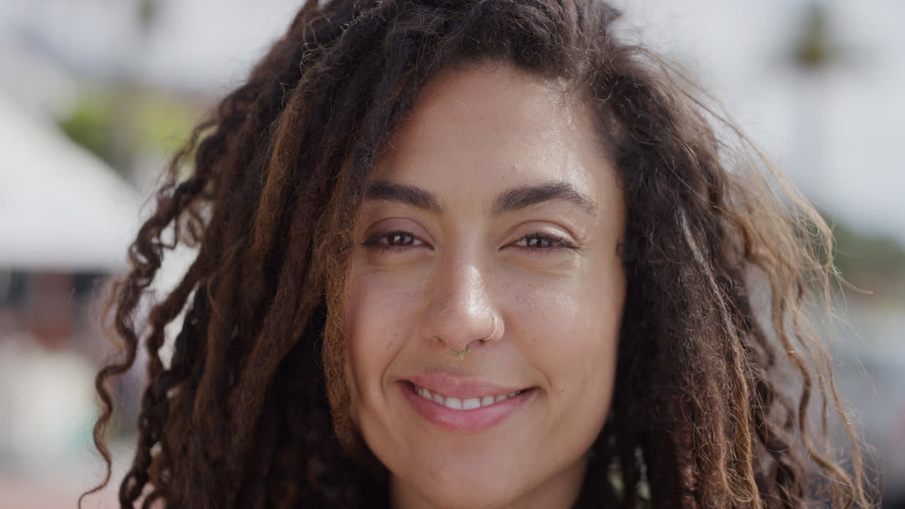 retrato en primer plano de una mujer hispana atractiva sonriendo feliz disfrutando de un día soleado en unas vacaciones vibrantes frente a la playa urbana