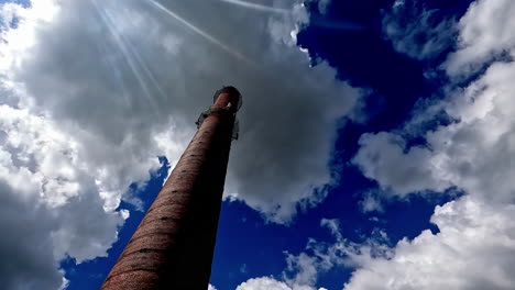 zeitraffer eines schornsteins oder eines hohen turms mit blauem himmel und weißem wolkenhintergrund