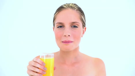 blond woman holding a glass of orange juice