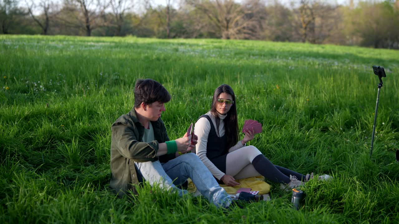 Couple Playing Cards in a Park