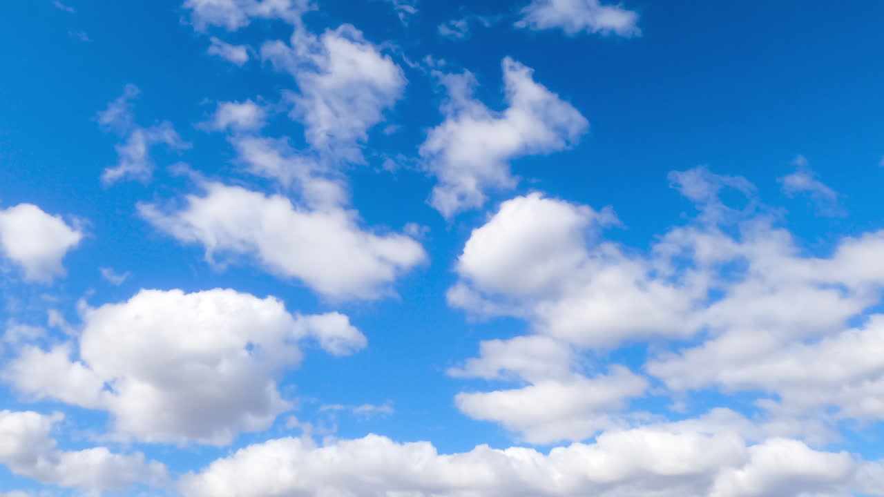 Fluffy soft white clouds moving by the azure skies. Cloudscape formation in the atmosphere. Timelapse.