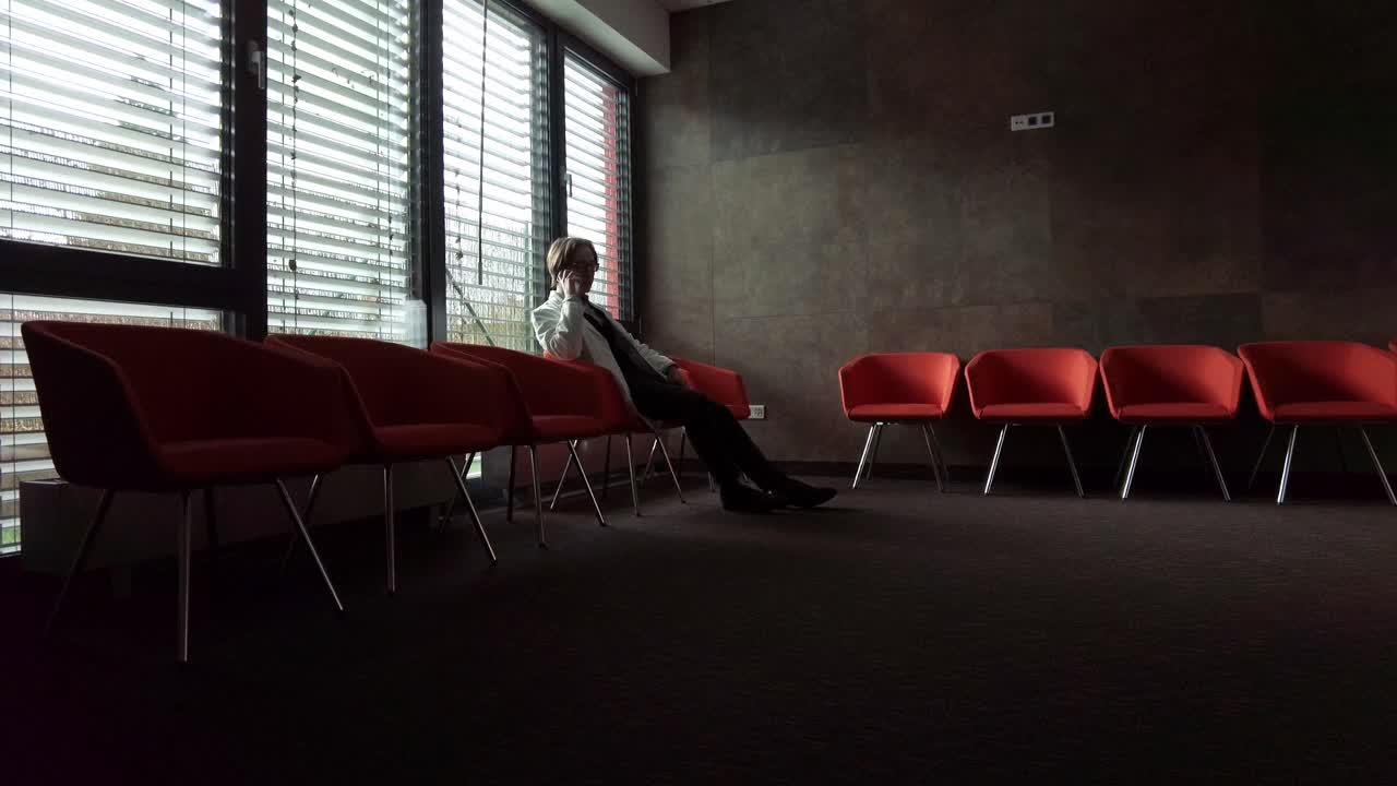 médico hablando con un abrigo en una habitación oscura con rayos brillantes en un hospital durante una pandemia