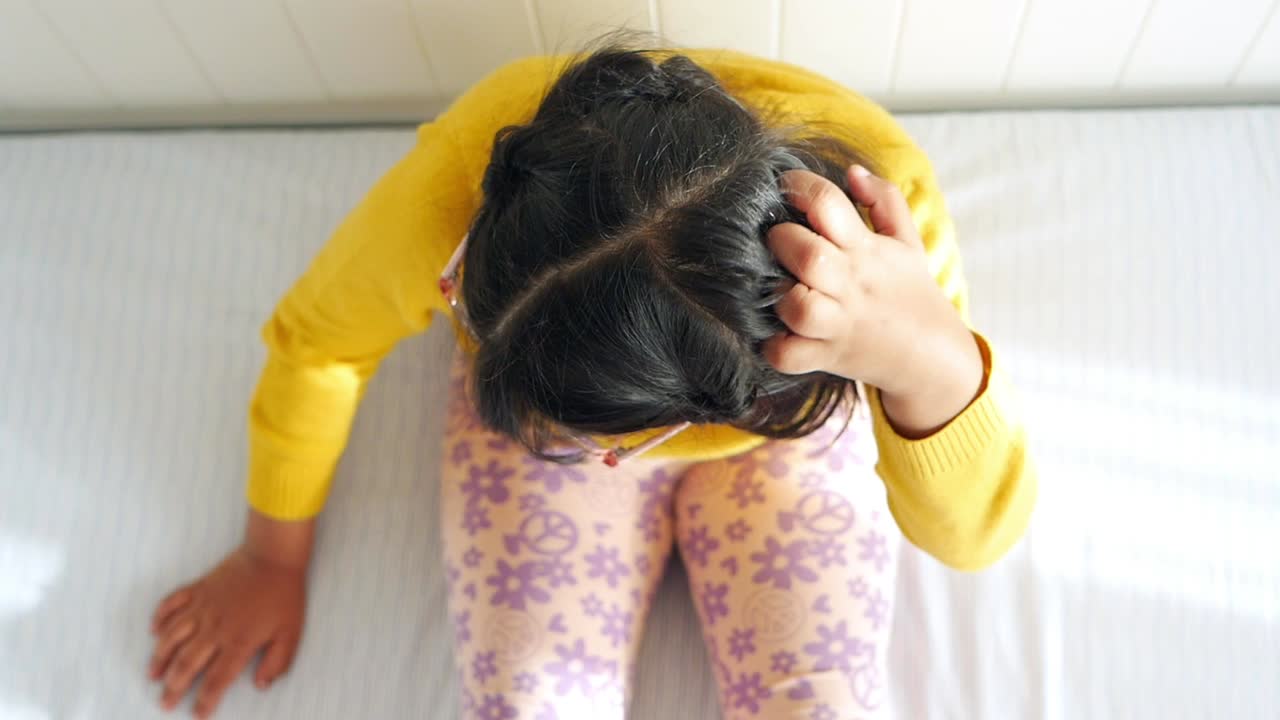 침대에 머리를 고 있는 소녀