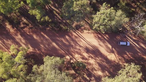 Vista-De-Arriba-Hacia-Abajo-De-Un-Coche-Que-Pasa-Y-Conduce-Por-La-Icónica-Carretera-De-Tierra-Roja-Australiana