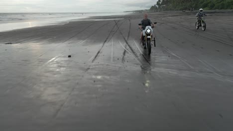 las motocicletas aéreas conducen en la playa de arena con el cielo nublado de la mañana