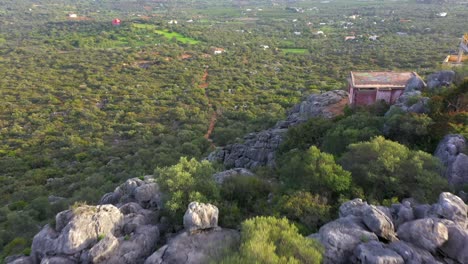 el dron vuela sobre un acantilado rocoso durante el día para revelar un paisaje escénico verde épico, aéreo
