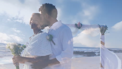 animation of happy newly married african american couple over clouds and seascape