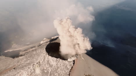 aerial view over crater of fuego volcano in guatemala while smoke is coming out