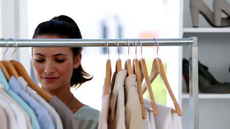 smiling young woman choosing clothes