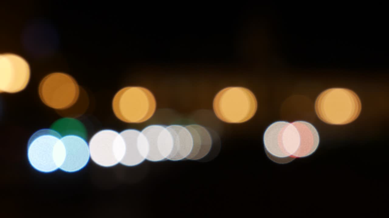 hermoso bokeh brillante en el fondo oscuro borroso por la noche. el redondo bokeh colorido brilla de las luces de los coches en la calle de la ciudad. fuera de foco con borroso. luces de la ciudad sin enfoque. bokeh de tráfico. concepto abstracto