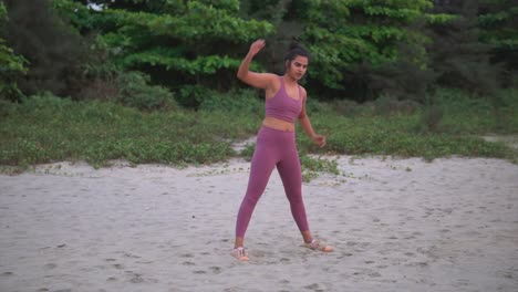 indian fitness woman in pink sportswear doing warm up exercise in nature