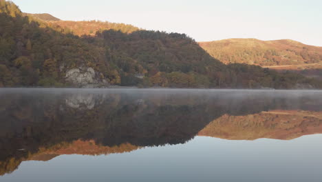 Eine-Spiegelreflexion-Von-Bäumen-Mit-Herbstfarben-Vom-Ullswater-Lake