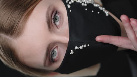 vertical close up of woman in beaded face mask