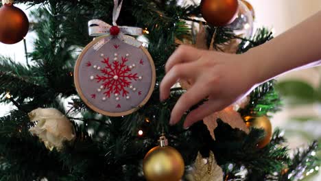 manos de niña arreglando decoraciones para árboles de navidad