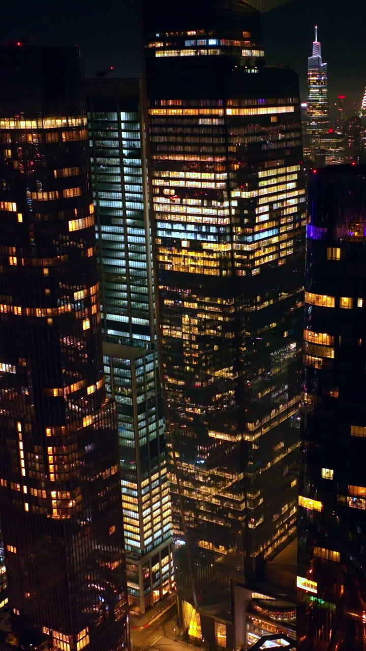 Multiple lights in the windows of amazing New York. Drone footage flying slowly among the marvelous skyscrapers. Vertical video