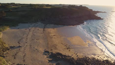 Rising-shot-of-a-beautiful-empty-beach-surrounded-by-cliffs-in-Saussaye-beach,-Cancale,-France