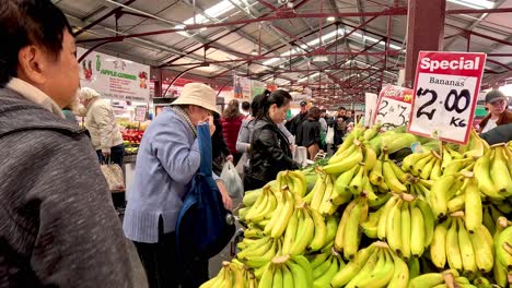 people buying bananas at a market stall