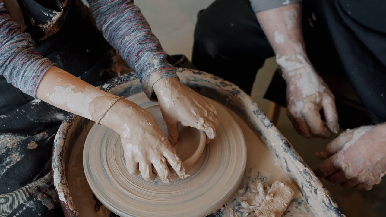 Child and Adult Learning Pottery on a Wheel