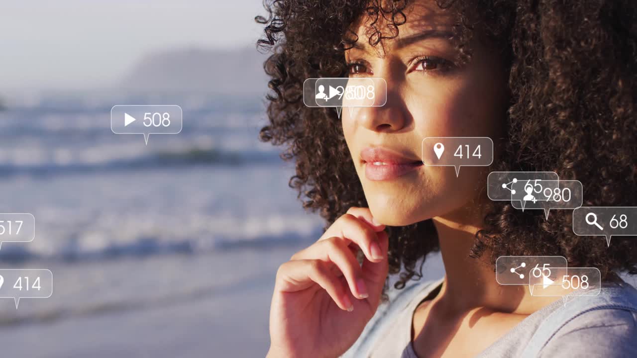 woman standing at beach during camera zoom, generating social media icons indicating engagement