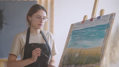 An-old-retired-woman-paints-a-picture-together-with-friends.-An-elderly-group-of-friends-and-a-senior-woman-are-drawing-pictures-together.