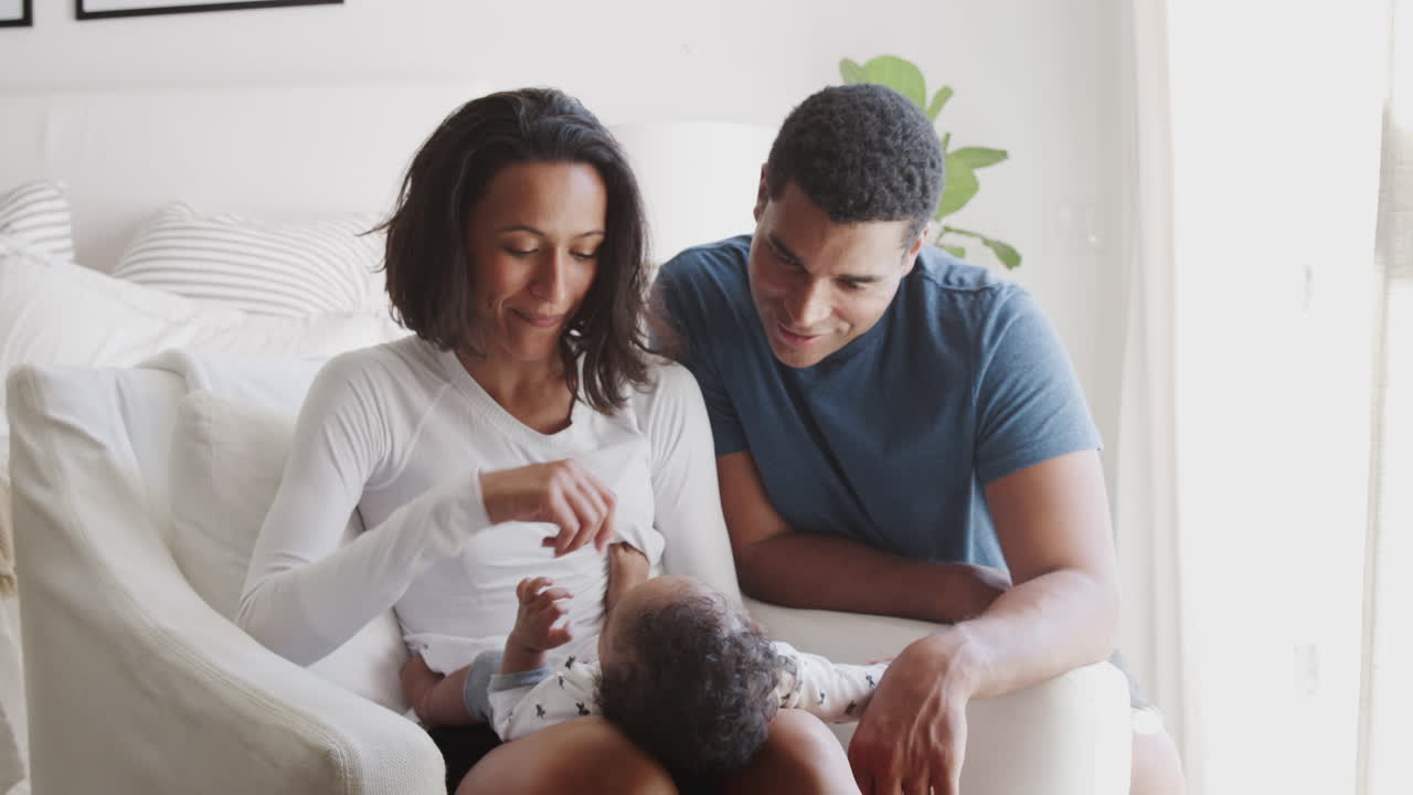 Happy young African American parents spending time with their baby son, close up