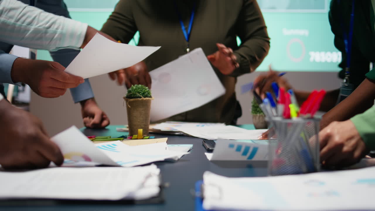 Multiethnic team reviewing analytics in a late night company briefing
