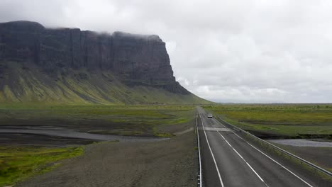 Car-driving-in-Iceland-on-Ring-Road-through-mountains-with-drone-video-moving-up