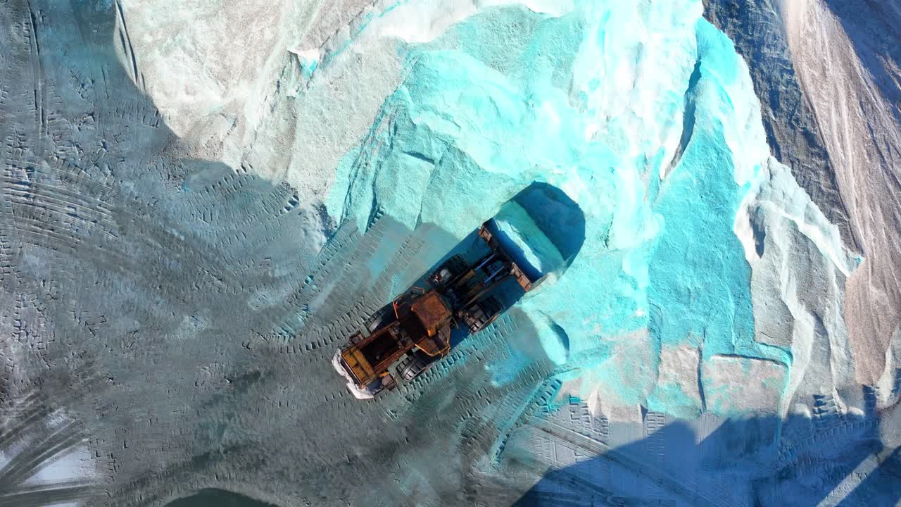 Aerial view of loader scooping salt into dump truck at Detroit salt depot