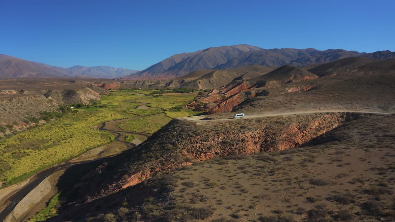antena - hermosa vista de una furgoneta en un camino sinuoso en medio de las colinas bajo un cielo azul