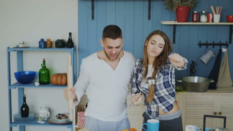 pareja cantando y bailando en la cocina