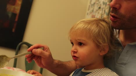 padre alimentando al bebé en casa en 4k. padre nutriendo al niño pequeño