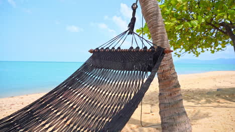 Close-up-of-an-empty-rope-hammock-shifting-in-the-tropical-breeze