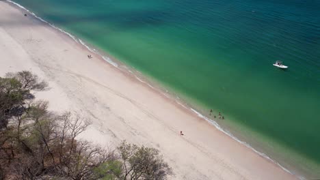 white sand and blue ocean scenery of conchal beach, costa rica, 4k drone zoom into water