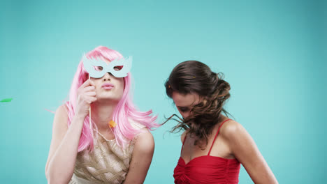 girlfriends dancing wearing red dress and pink hair in slow motion party photo booth