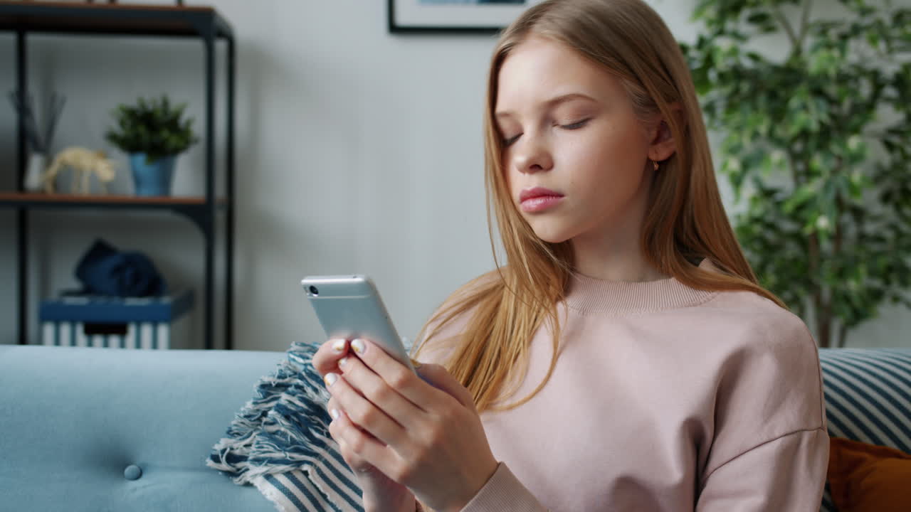 Teenage girl using smartphone at home
