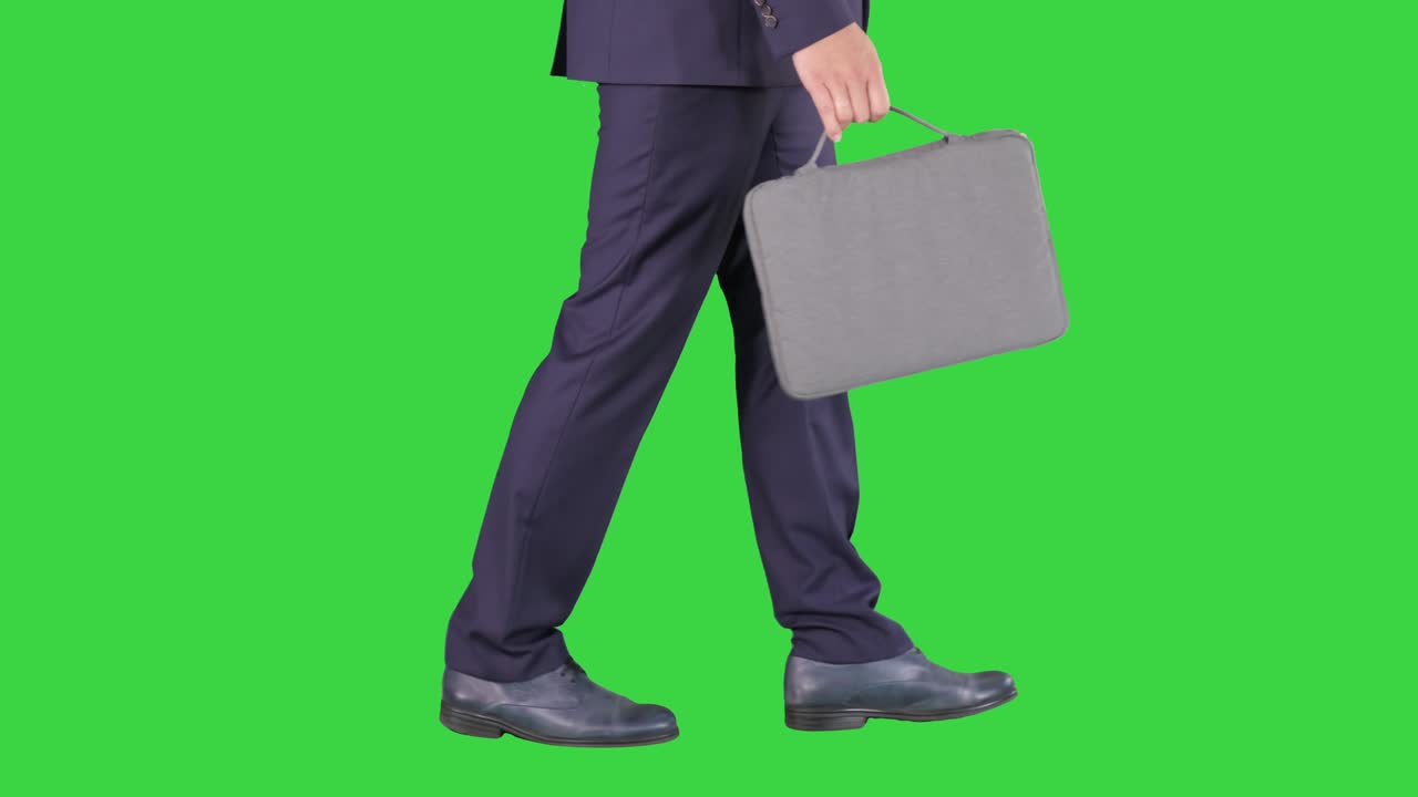 Handsome businessman in a suit walks with a briefcase on a Green Screen, Chroma Key