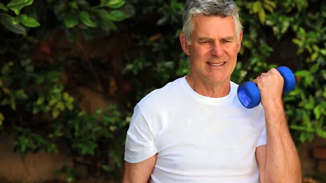 mature man exercising with dumbells outdoors