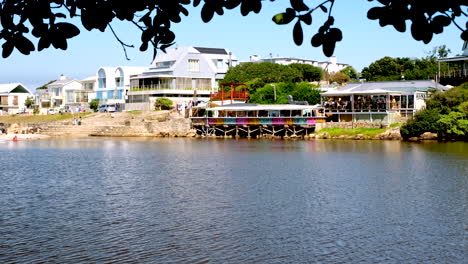 daytime view over onrus river lagoon of coastal houses and colorful restaurant