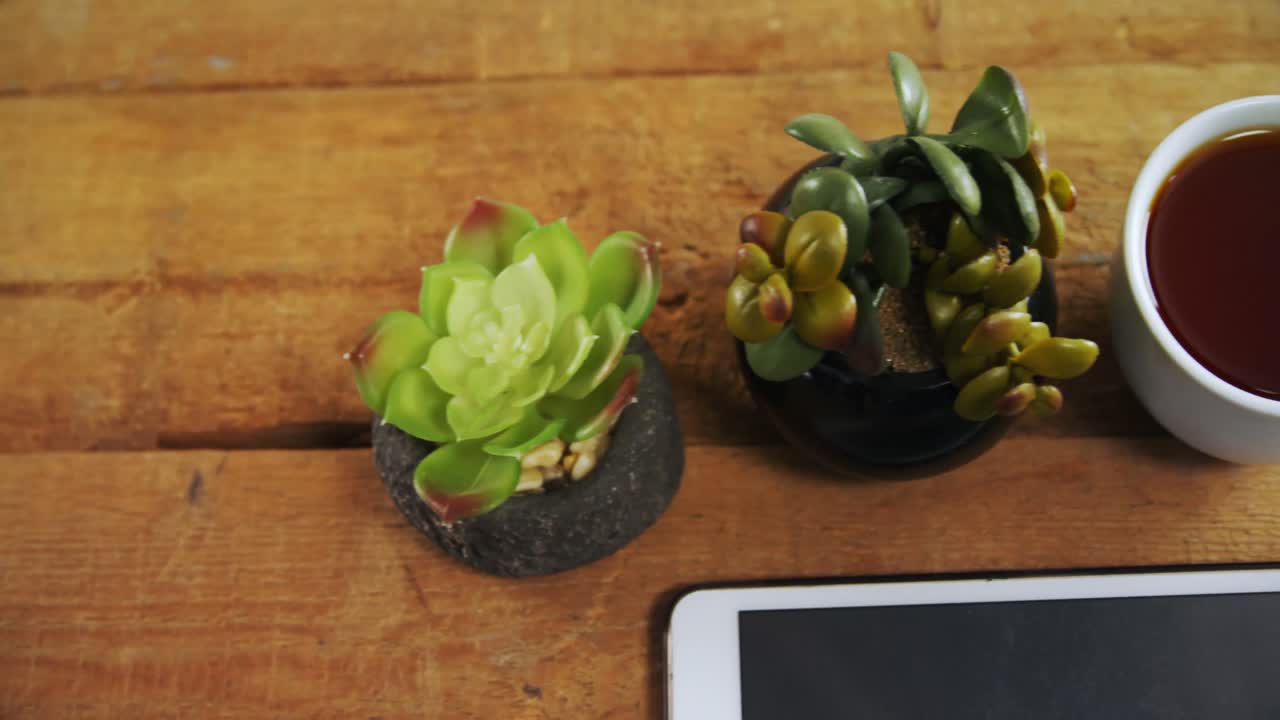 planta de olla, café negro, gafas y tableta digital en una mesa de madera 4k