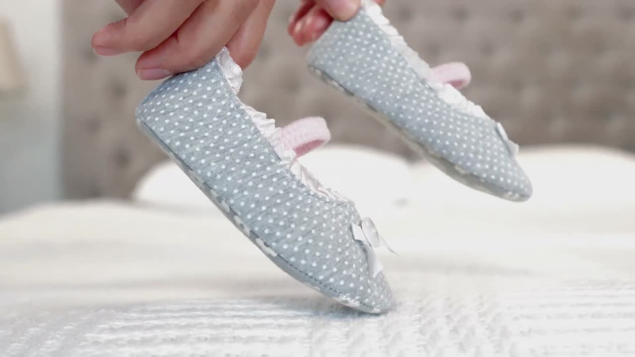 Donna che gioca con le scarpine del suo bambino