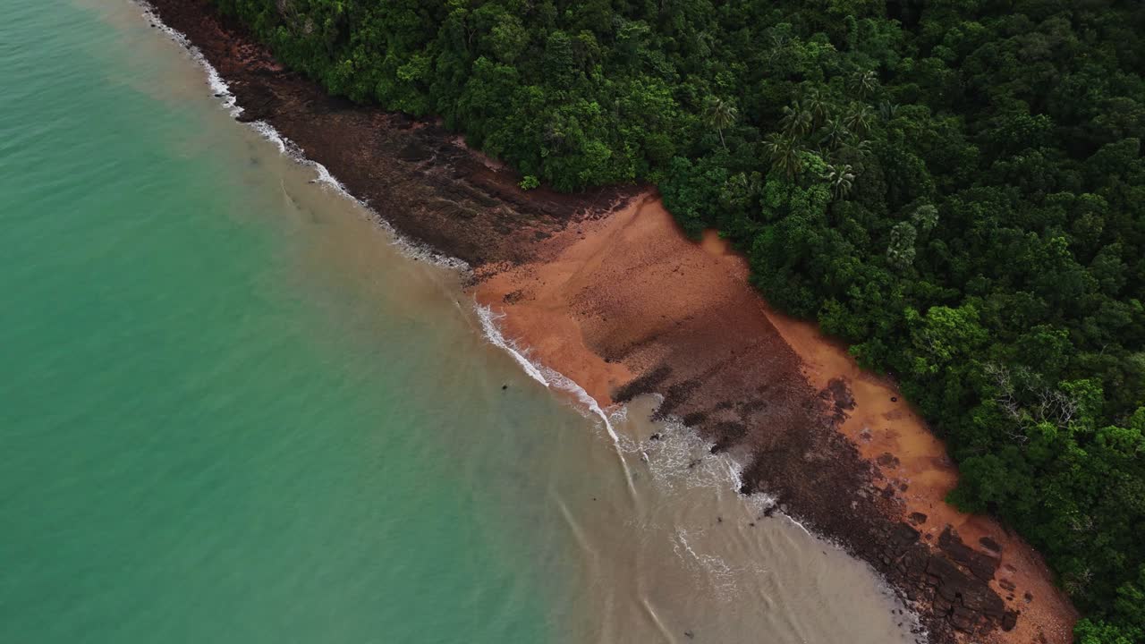 imágenes aéreas de drones de las olas en la playa de arena naranja de lanta con bosque