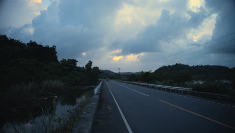 a road on an island in the philippines with a tuktuk approaching