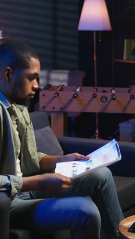 Vertical Video African american guy does research by reading articles and data driven papers