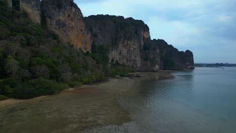 limestone karst formations at low tide, railay beach krabi, thailand. wonderful aerial view flight descending drone